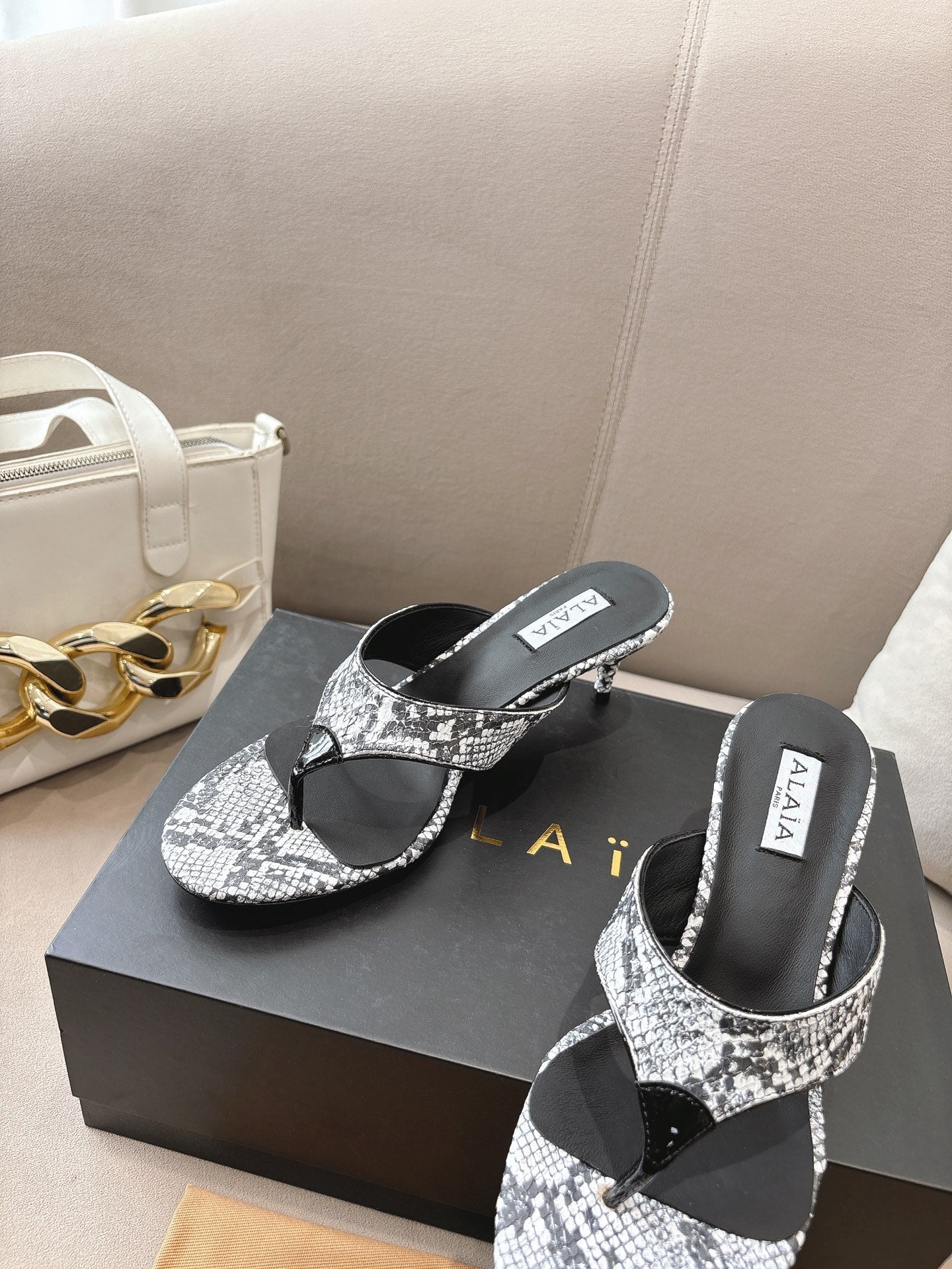 ALAIA HEELED THONG SANDALS 25S 55MM IN WHITE AND BLACK LAMBSKIN SNAKE-EMBOSSED